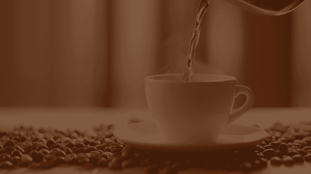 Coffee being poured into a mug surrounded by beans symbolizing the barista skills taught at Kemesha Academy.”